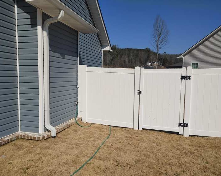 Pro vinyl fencing at side of house with a gate.